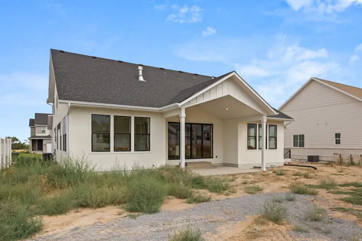 Contemporary architectural style with a covered patio, multiple windows, and a dark shingle roof