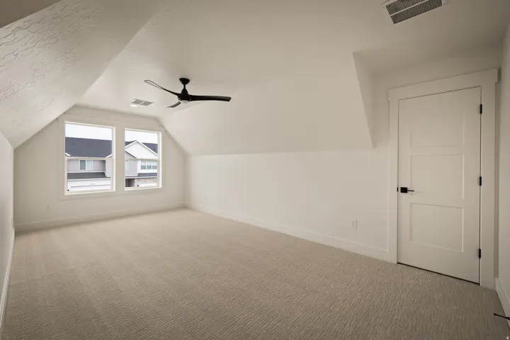 Sloped ceilings, dual windows, and light-toned carpeting