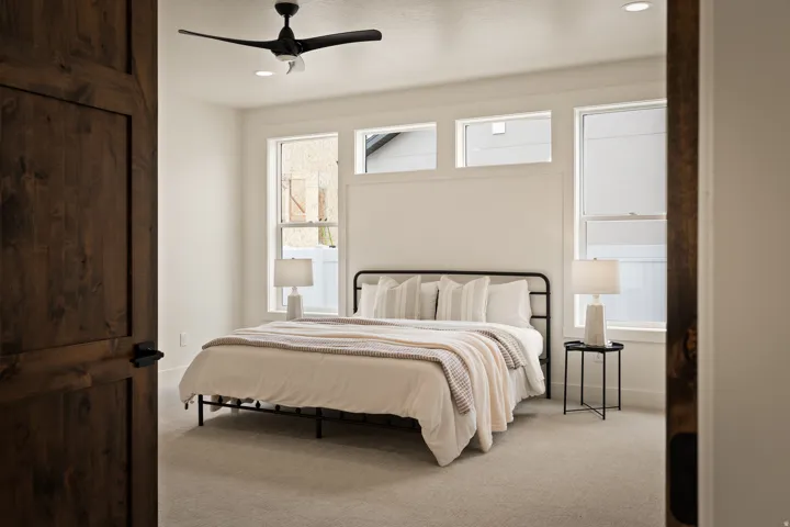 Wood-finish door, light-toned carpeting, ceiling fan, recessed lighting, and a series of windows