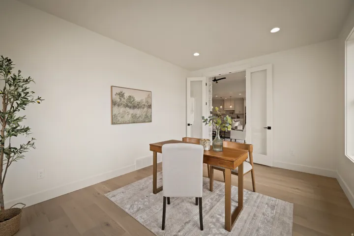 Main floor office with glass doors into living room/kitchen area