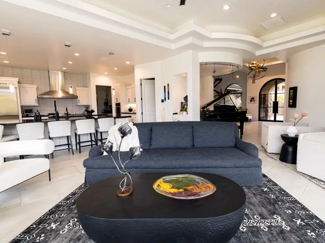 Open-concept living area featuring a tray ceiling, recessed lighting, and tile flooring