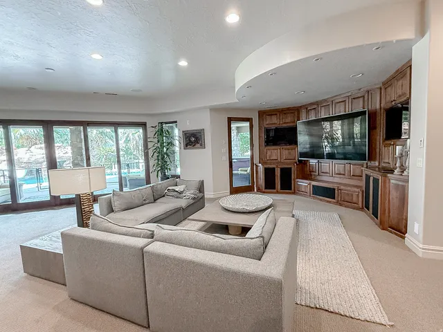Curved built-in entertainment center with extensive cabinetry and integrated media displays