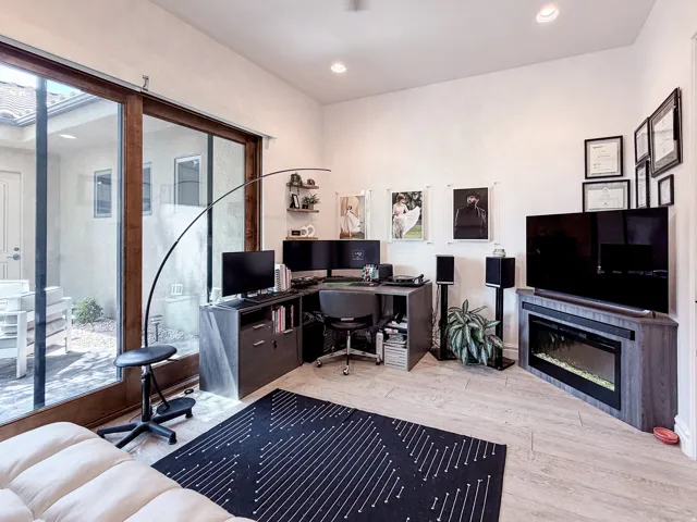 Recessed lighting, large sliding glass door, tiled flooring, built-in corner fireplace, and an outdoor patio space
