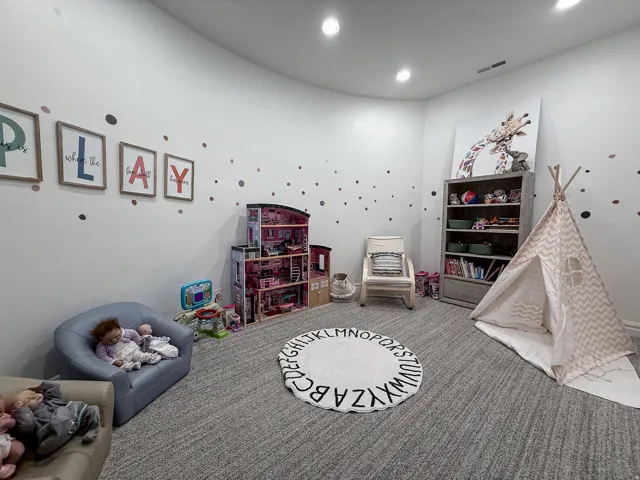 Recessed lighting, light gray wall finish, and gray textured carpeting