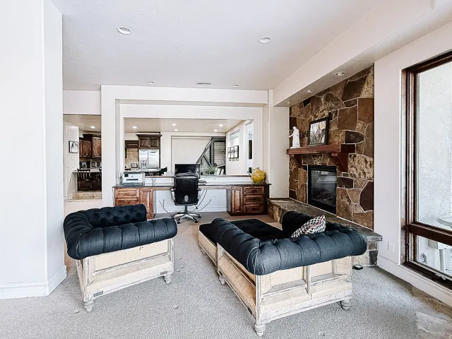 Stone-clad fireplace with a wood mantel, recessed lighting, and a built-in electric insert