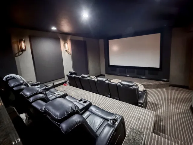 Dedicated theater space featuring a large projection screen and tiered seating