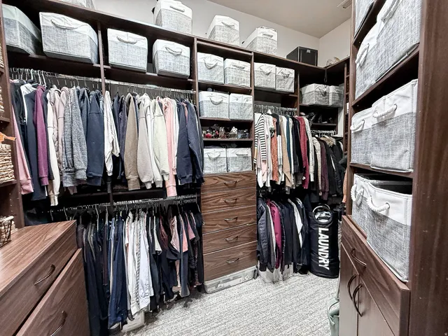 Built-in closet system with multiple shelving units, hanging rods, and integrated drawer storage