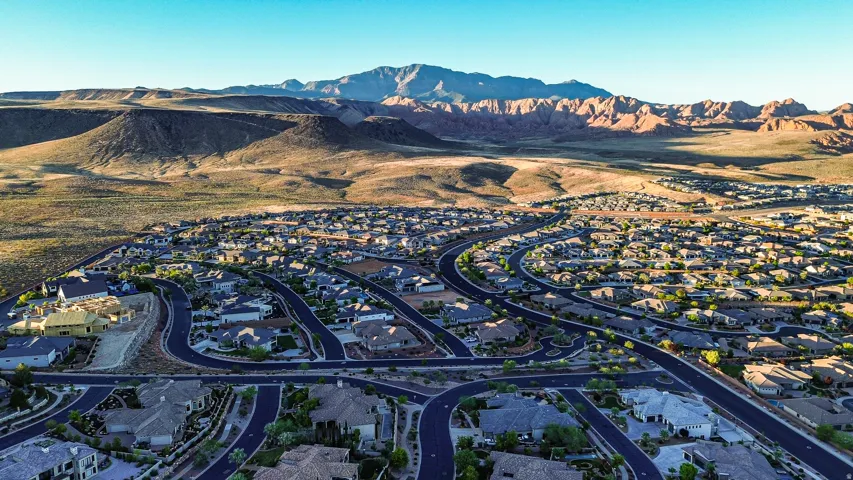 Expansive residential community with extensive paved roadways, surrounded by arid terrain and distant mountains