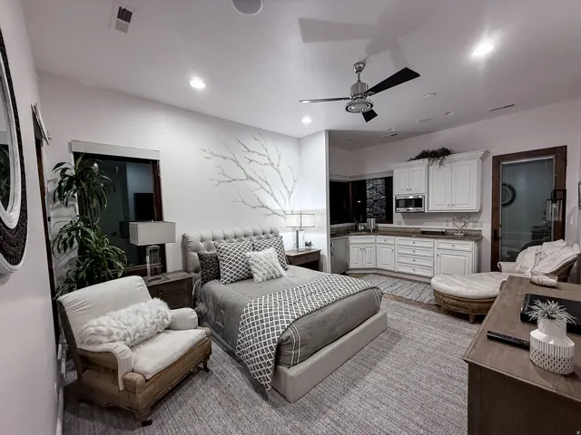 Integrated kitchenette with white cabinetry and a built-in microwave