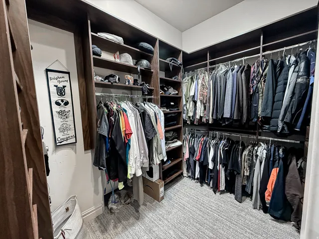 Custom closet system with wood-finish shelving, multiple hanging rods, and integrated storage compartments