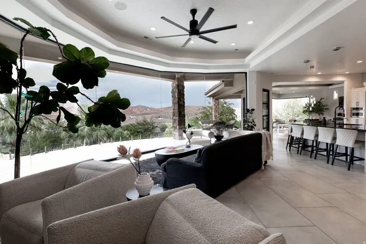 Expansive living space featuring floor-to-ceiling windows, a modern ceiling fan, recessed lighting, and large format tile flooring
