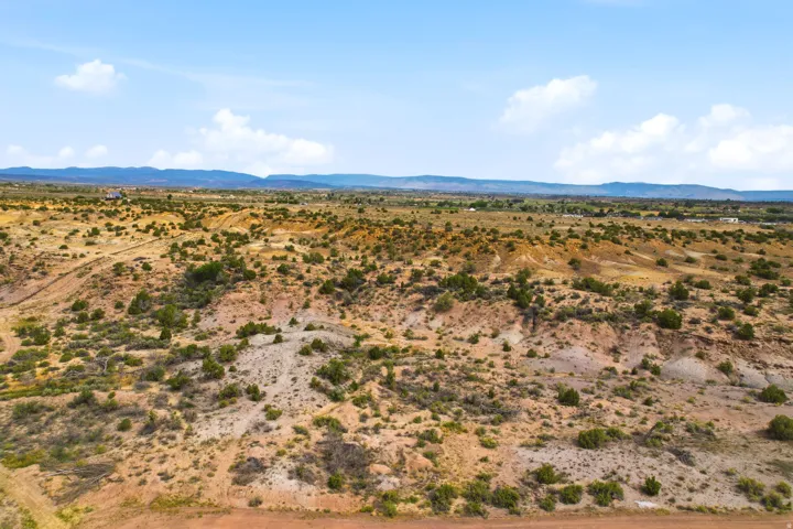 Expansive desert landscape with rolling terrain and scattered low-lying vegetation