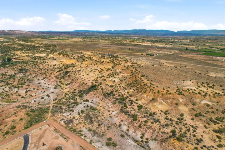 Expansive land featuring desert vegetation and distant mountain ranges