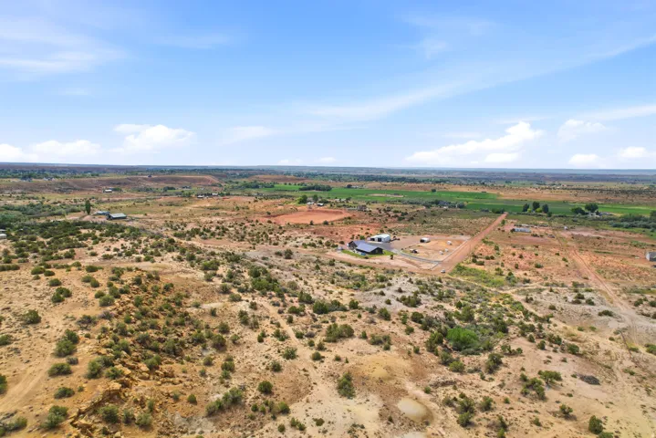 Expansive open terrain with natural vegetation and distant agricultural fields