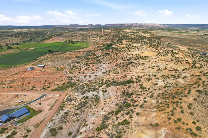 Expansive undeveloped land featuring varied topography, natural vegetation, and distant mountain ranges