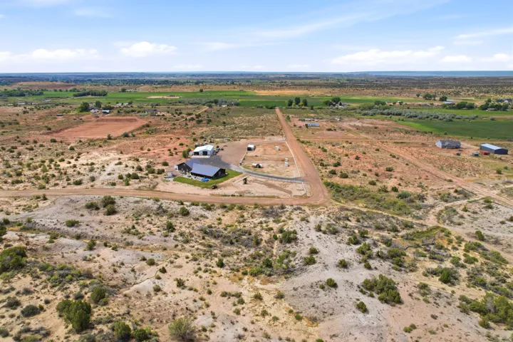 Expansive land parcel featuring a main residence, detached outbuilding, and solar panel array