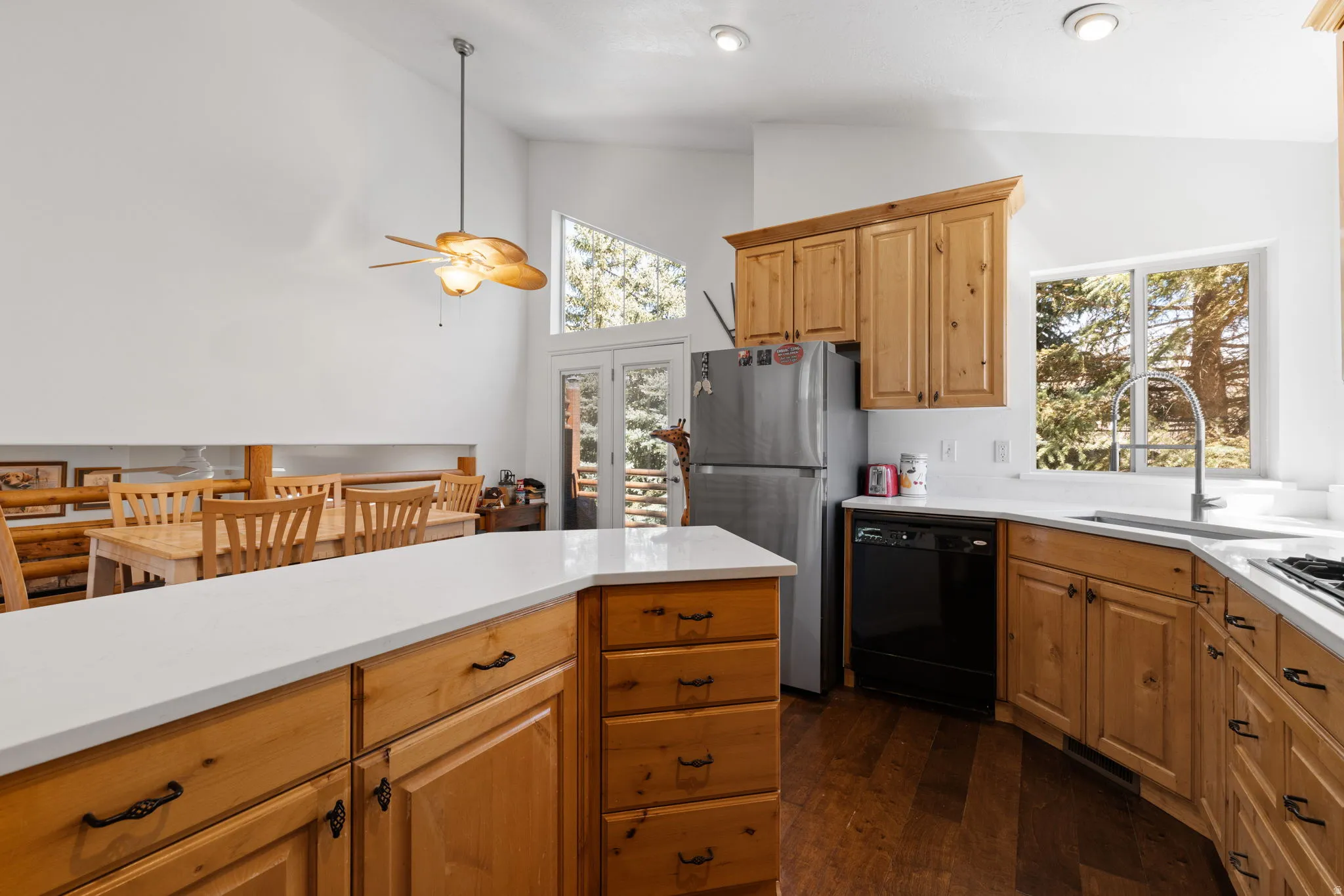 Kitchen featuring wood cabinetry, white countertops, built-in stainless steel appliances, and wood-finish flooring