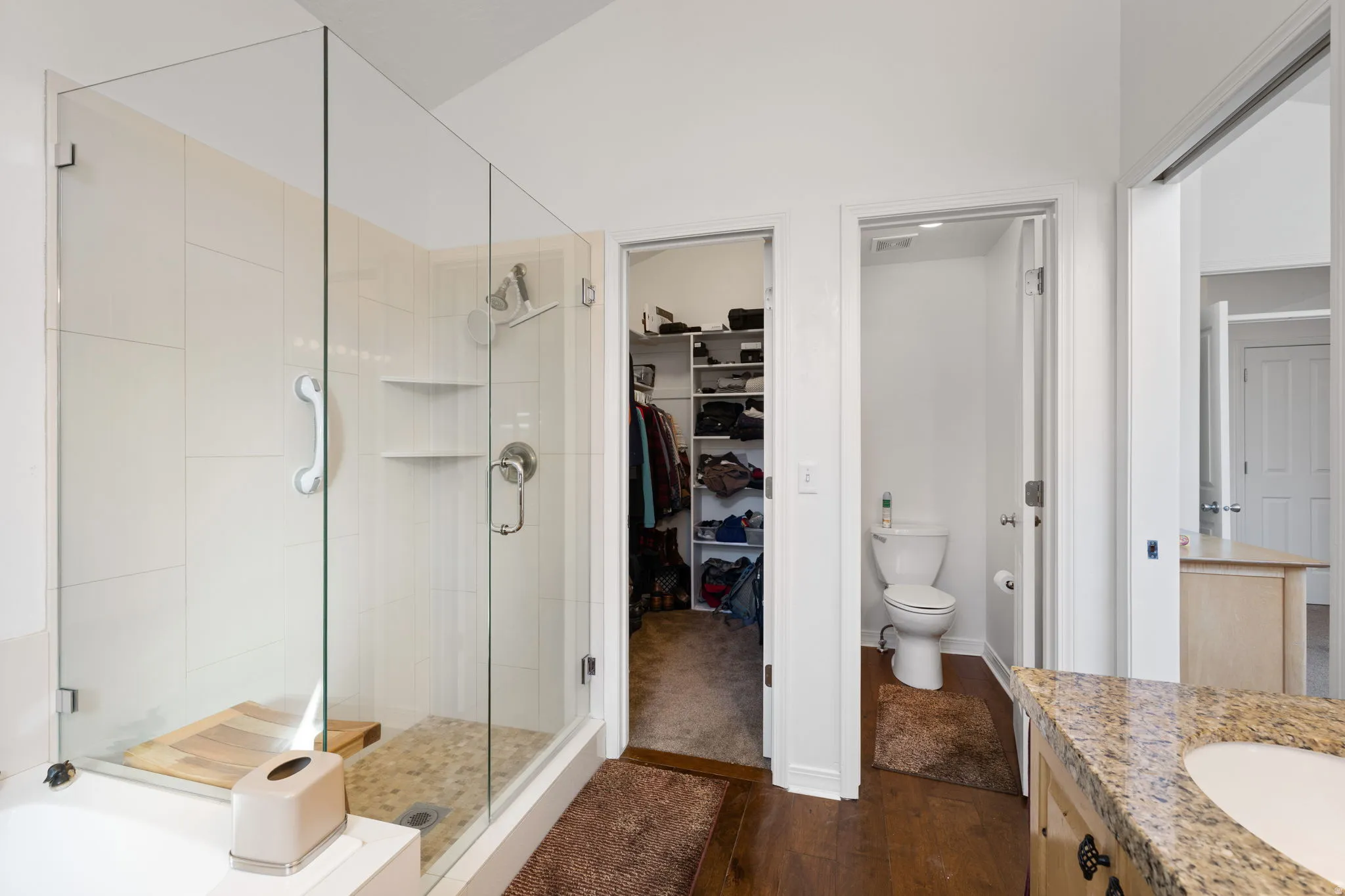 Contemporary bathroom featuring a frameless glass shower enclosure with white subway tile, a river rock shower base, and dual shower heads