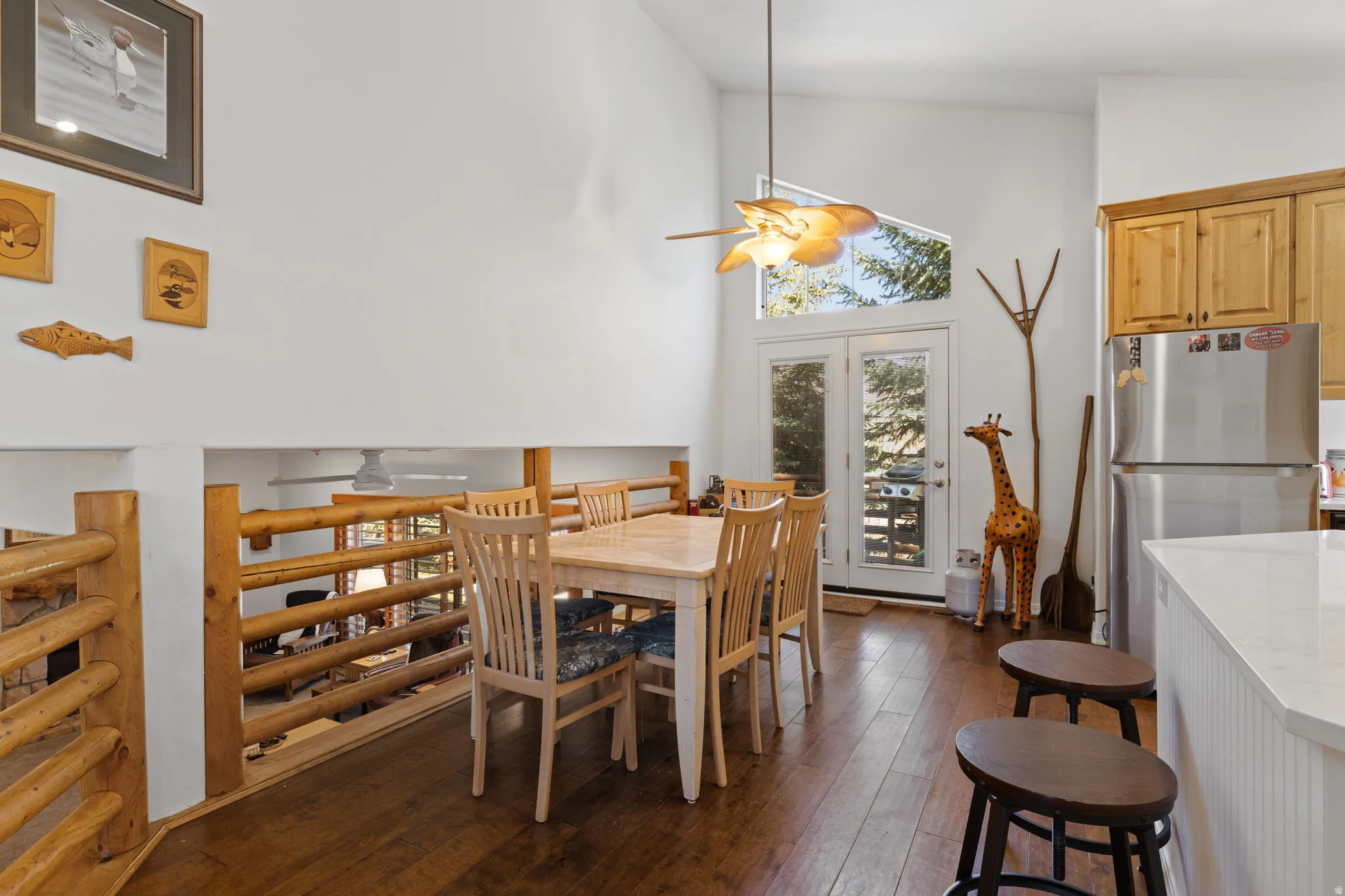 Dining area featuring vaulted ceilings, wood-finish flooring, and French doors with an arched transom window