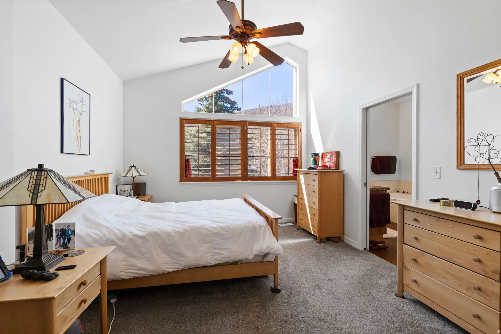Vaulted ceilings featuring a ceiling fan with integrated lighting