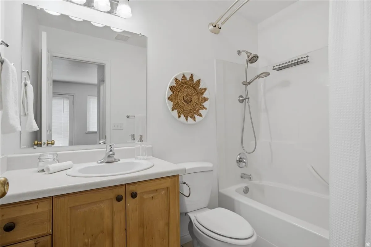 Wood-finish vanity with an integrated sink, polished chrome faucet, and a wall-mounted mirror