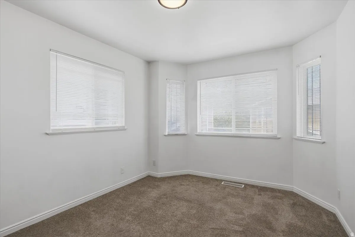 Recessed lighting, multiple windows, carpet flooring, and white interior paint