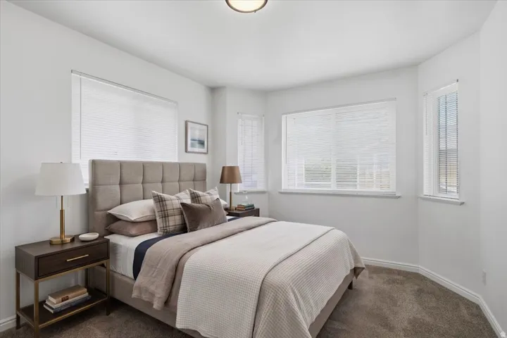 Recessed lighting, multiple windows with blinds, light-toned wall finishes, and carpeted flooring