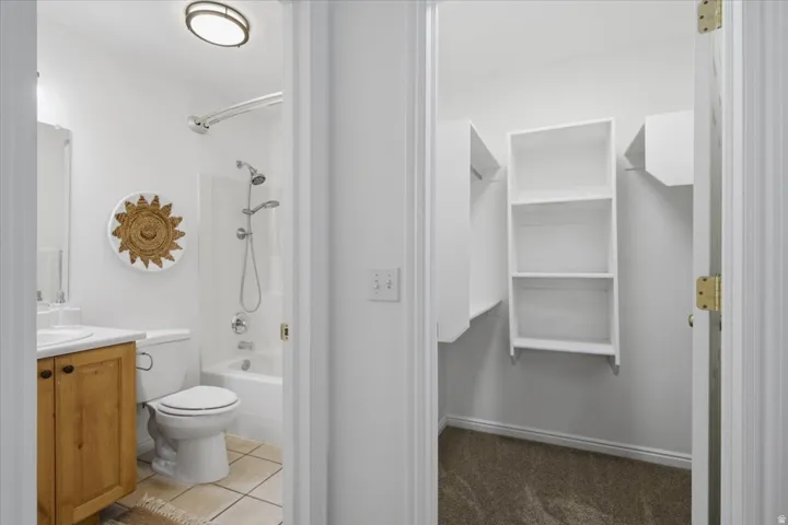 Full bathroom with a tub/shower combination, vanity with wooden cabinetry, and tile flooring