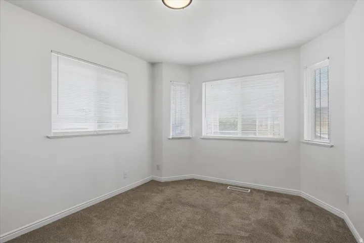 Recessed lighting, multiple windows, carpet flooring, and white interior paint