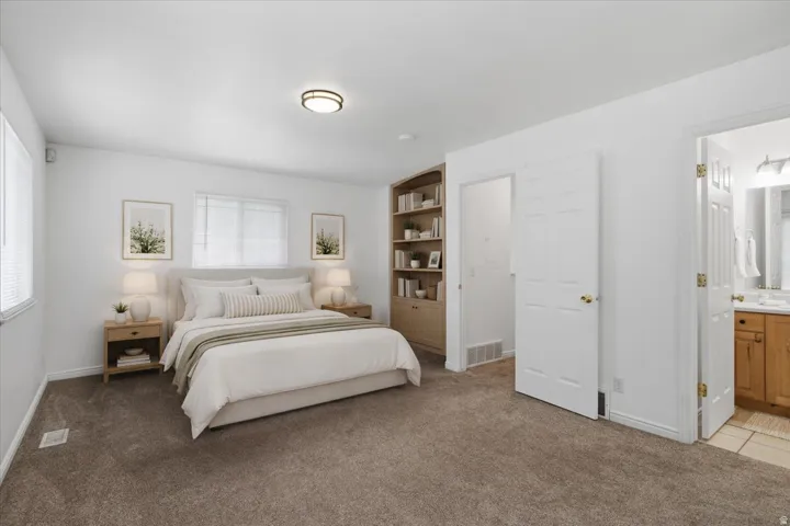 Recessed lighting, wood-finish built-in shelving, plush carpeting, and two windows with blinds