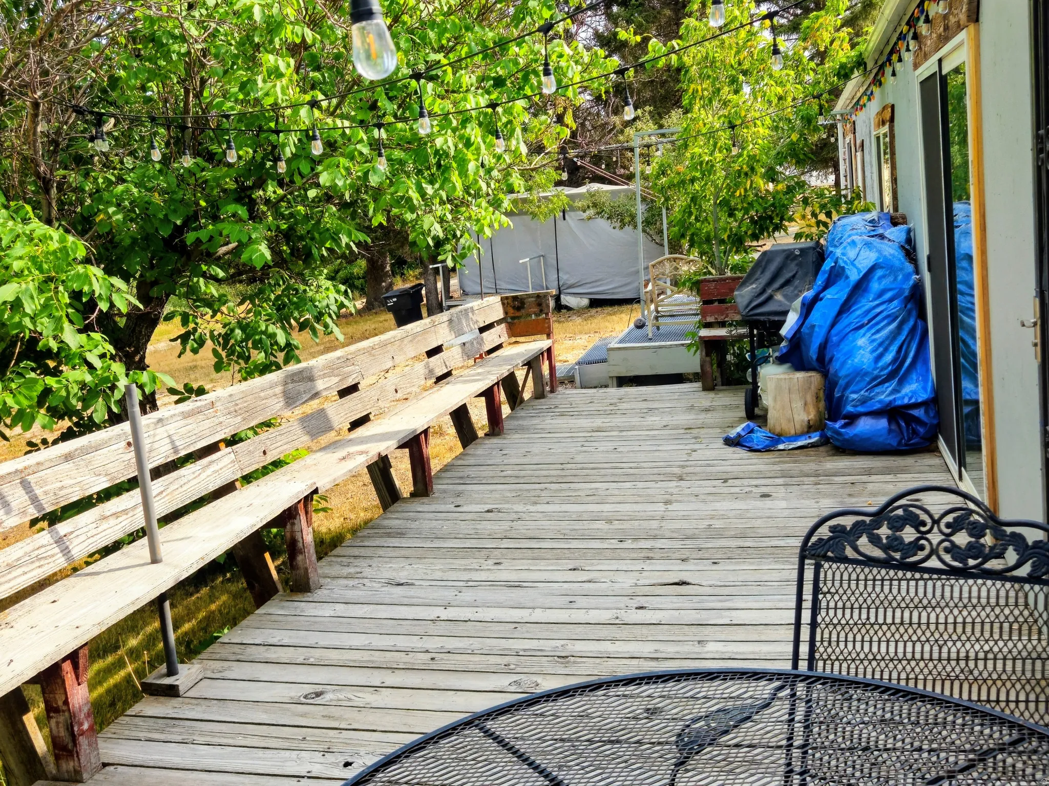 Expansive wooden deck with built-in bench seating and string lighting