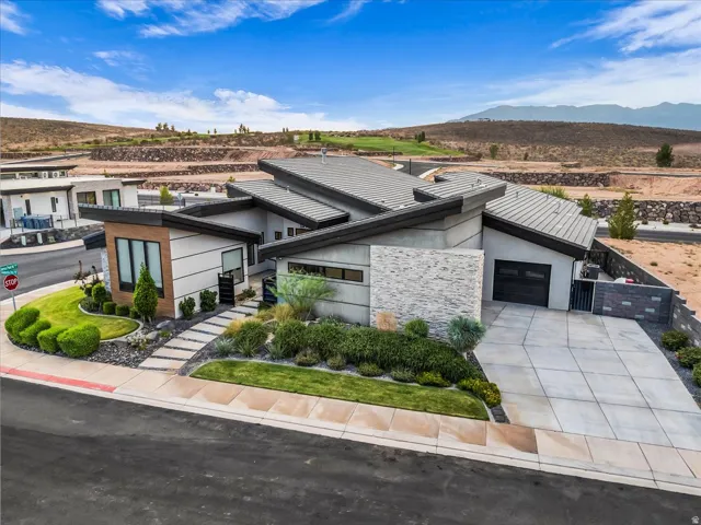 Modern exterior with a multi-level roofline, stone and stucco facade, and an integrated garage