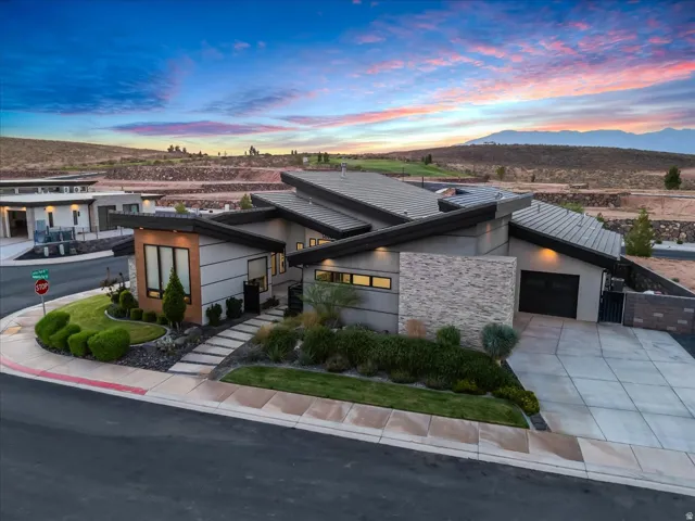 Contemporary architectural design with a multi-plane roofline, stone veneer accents, and a corner lot position