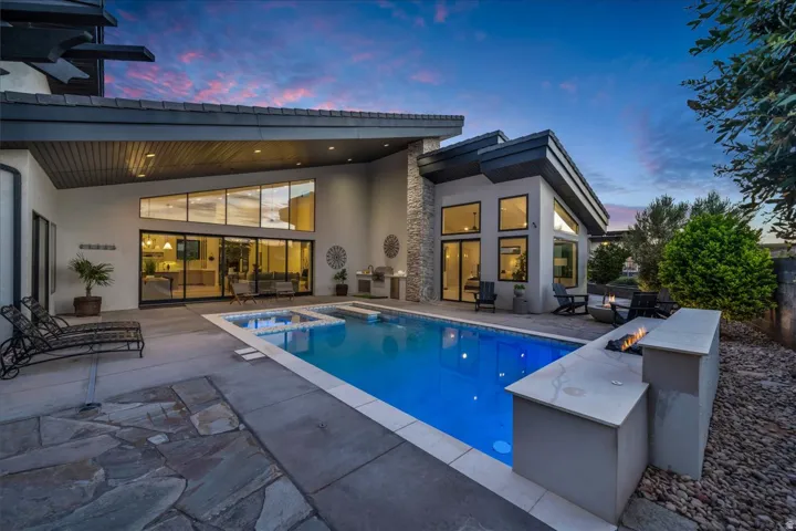 Modern exterior with a swimming pool, integrated spa, and an outdoor fire feature