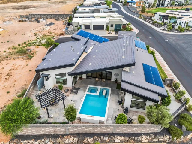 Contemporary residence featuring a private pool with an integrated spa, expansive patio, and a pergola