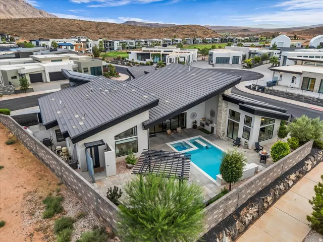 Modern exterior with an angular roofline, a built-in pool, integrated spa, and a stone-clad wall accent
