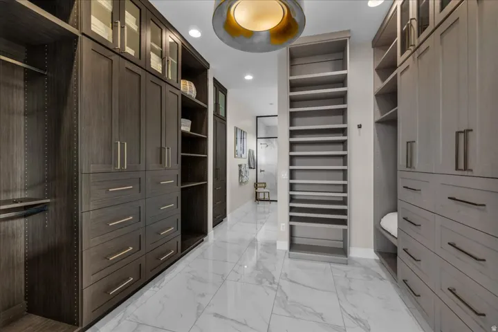 Custom built-in cabinetry with varied storage options, glass-front upper cabinets, and gold-tone hardware