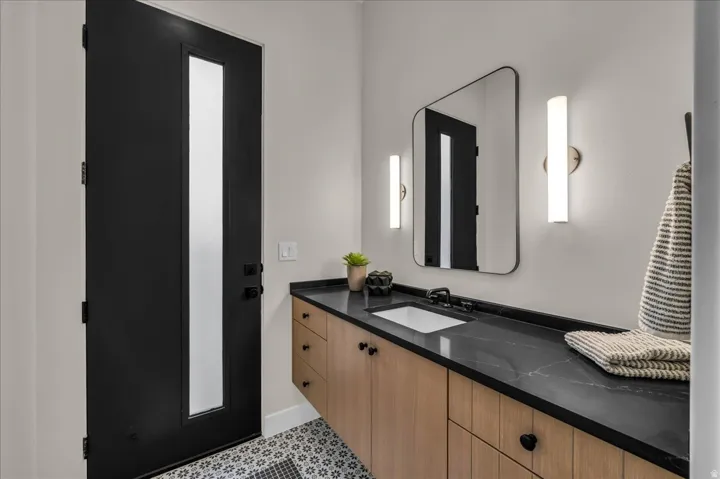 Floating wood-finish vanity with a dark countertop and undermount sink
