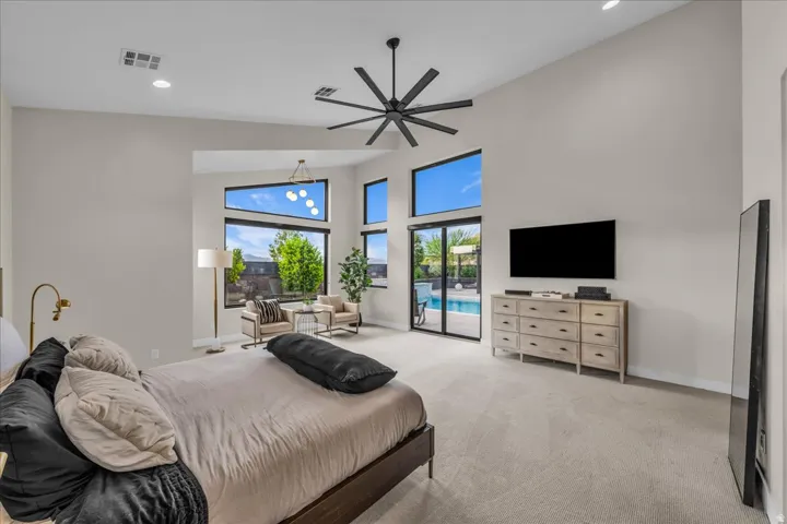 Vaulted ceilings, large format windows, full glass sliding door, recessed lighting, and a modern ceiling fan