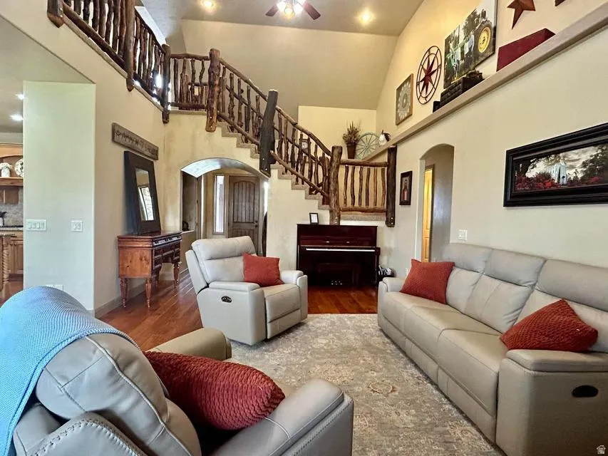 Vaulted ceilings, wood-finish flooring, custom wood staircase, arched doorways, and recessed lighting