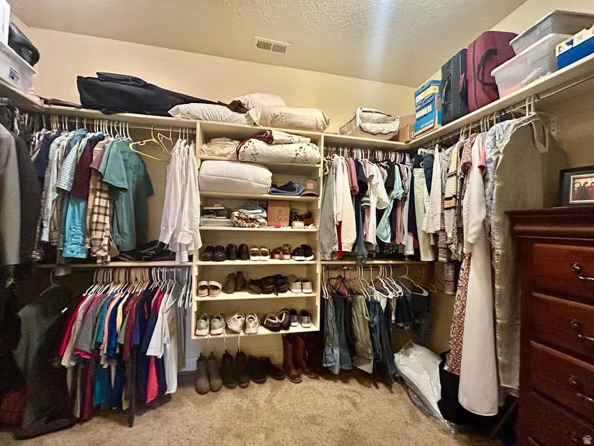 Walk-in closet featuring extensive shelving, multiple hanging rods, and built-in storage