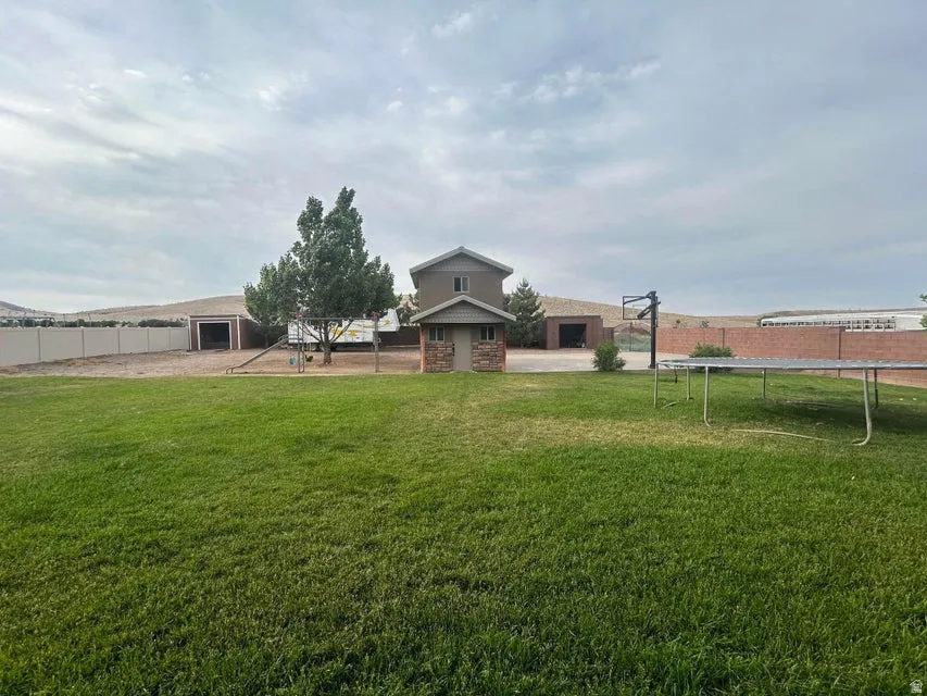 Expansive green lawn with a two-story storage shed featuring a stone facade