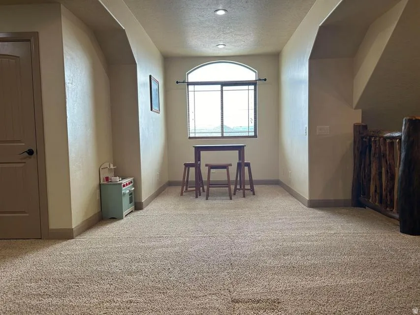 Recessed archways defining a spacious area with carpet flooring