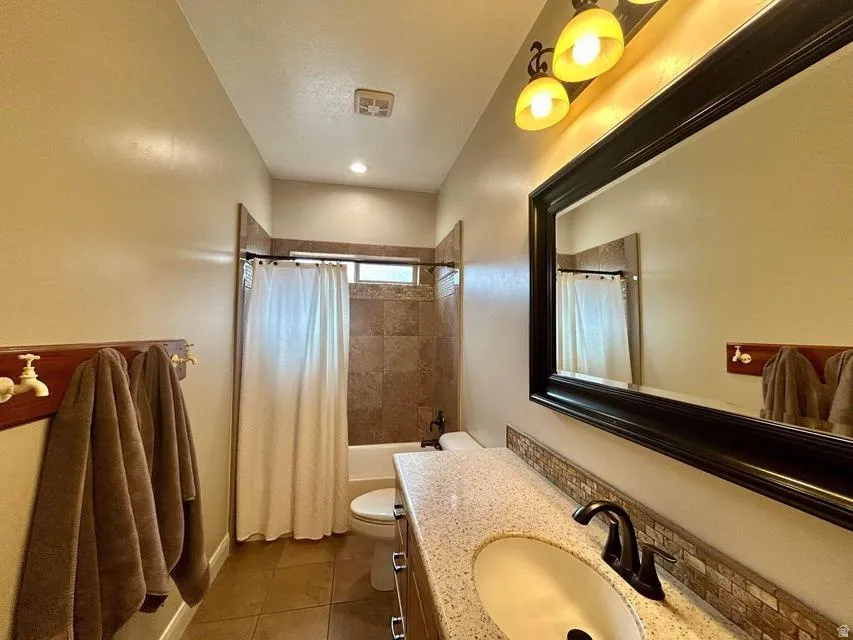 Granite-style countertop with an integrated sink, dark bronze-finish faucet, and a large framed mirror