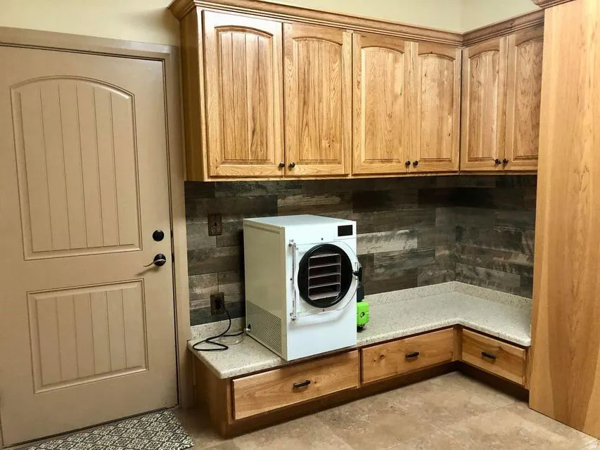 Light wood-finish cabinetry with crown molding, solid surface countertops, and a wood-look backsplash