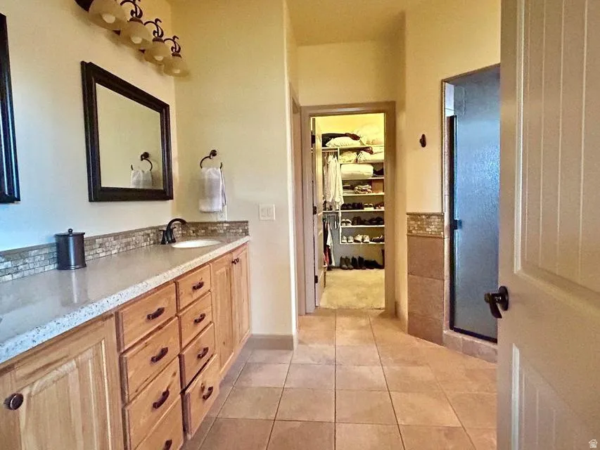 Extended vanity with light-toned countertop and wood-finish cabinetry