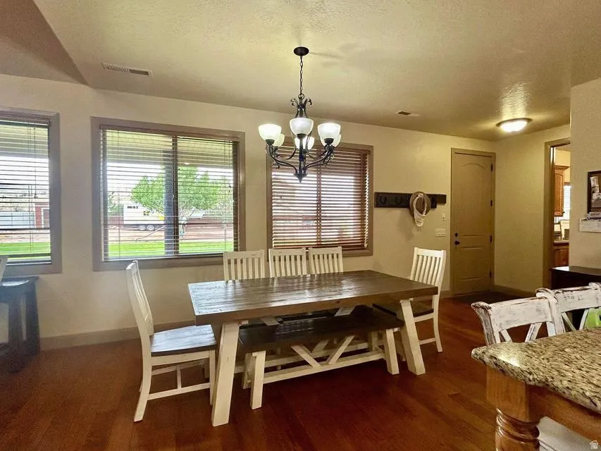 Wood-finish flooring throughout, featuring multiple windows with wood-tone blinds, and a built-in coat rack