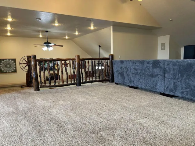 Loft area featuring vaulted ceilings, recessed lighting, a ceiling fan, and rustic wood railing