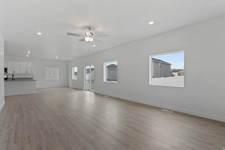 Open-concept living space featuring wood-finish flooring, recessed lighting, and a ceiling fan