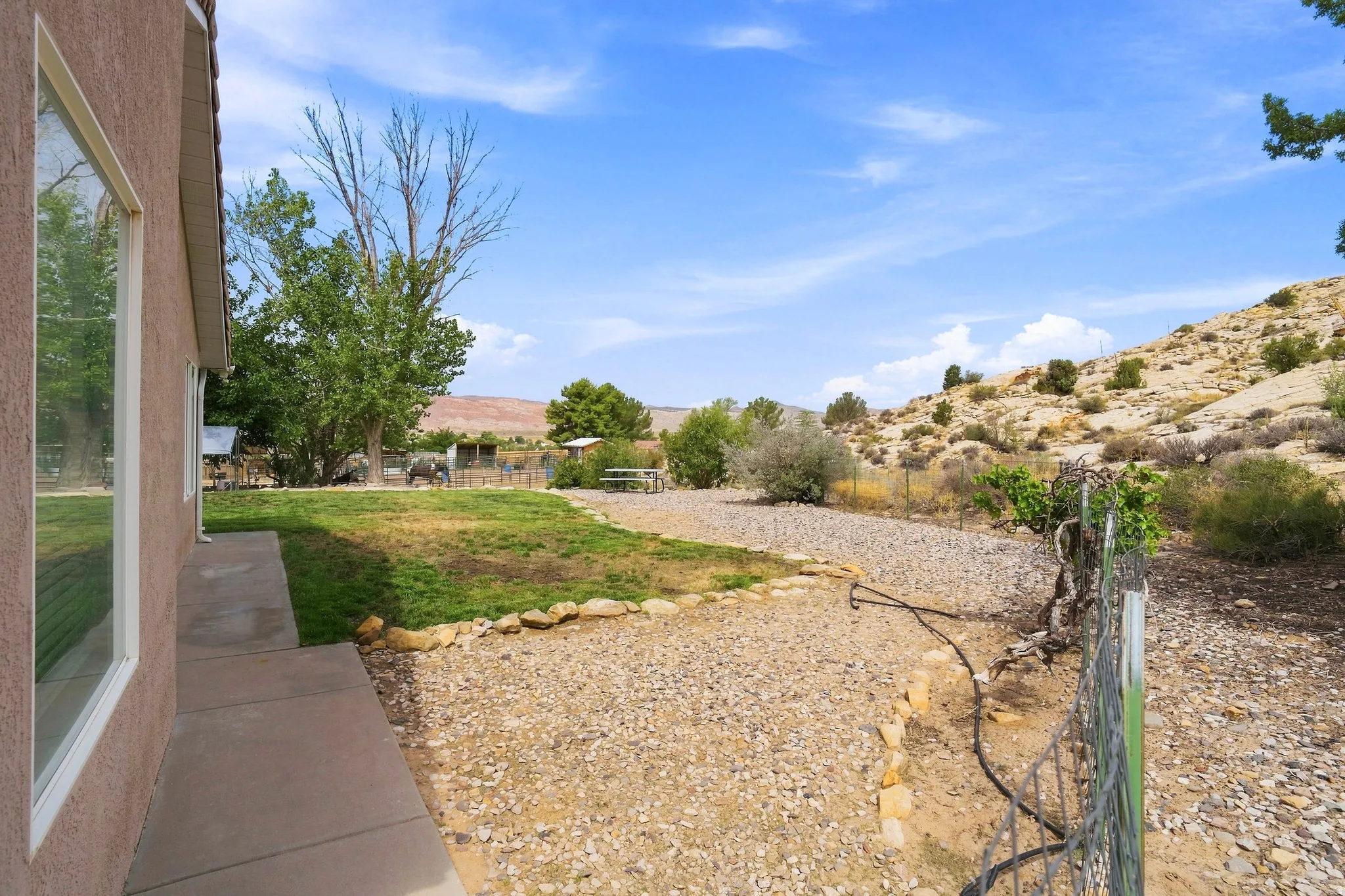 Expansive outdoor area featuring a combination of manicured lawn and gravel landscaping, with a concrete walkway bordering the building